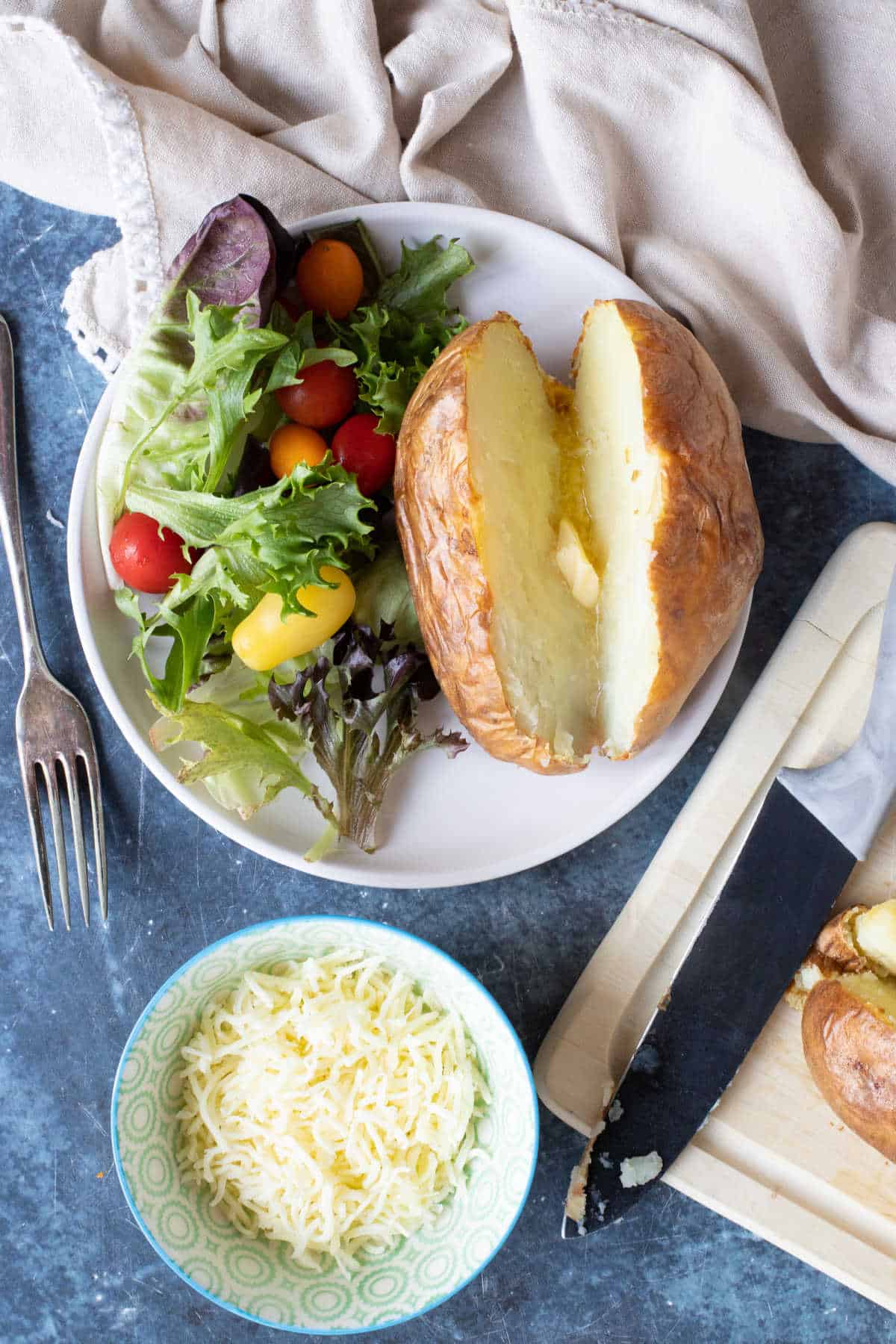 Air fryer jacket potato served with a salad.