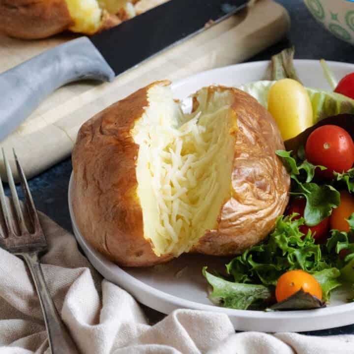 Air fryer baked potato with a side salad.