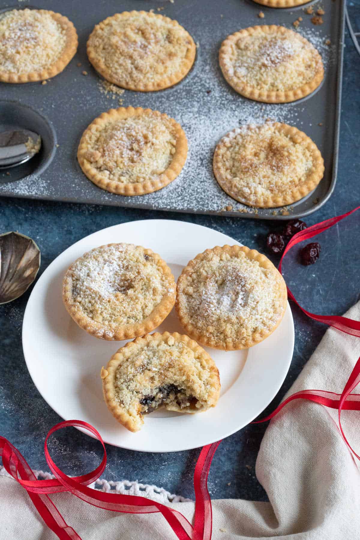 Crumble topped mince pies in a bun tin.