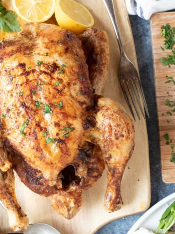 Air fryer whole chicken with herbs and lemon.