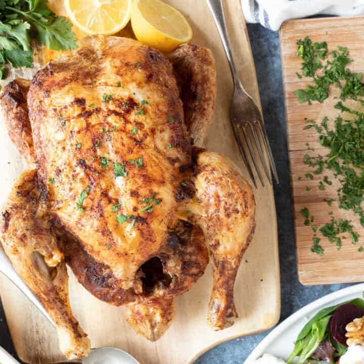 Air fryer whole chicken with herbs and lemon.