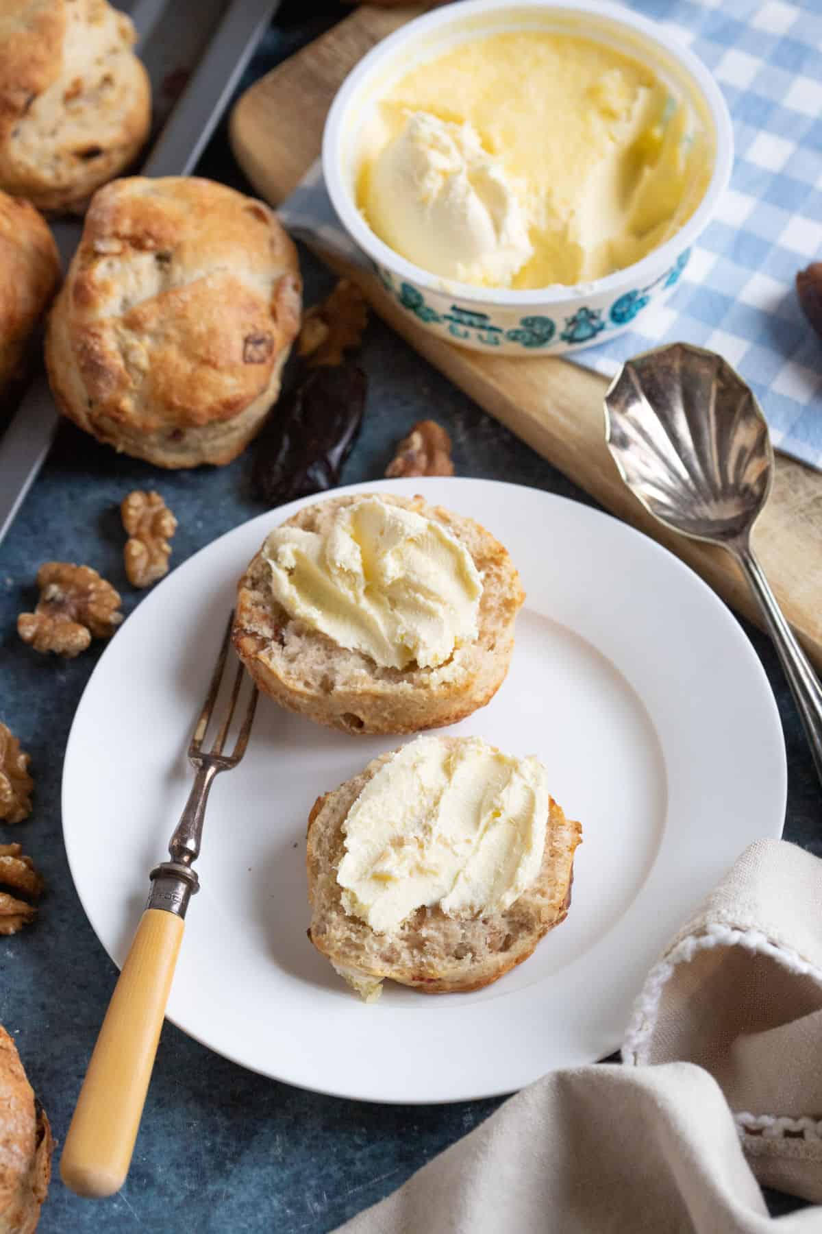 A date and walnut scone on a white plate.