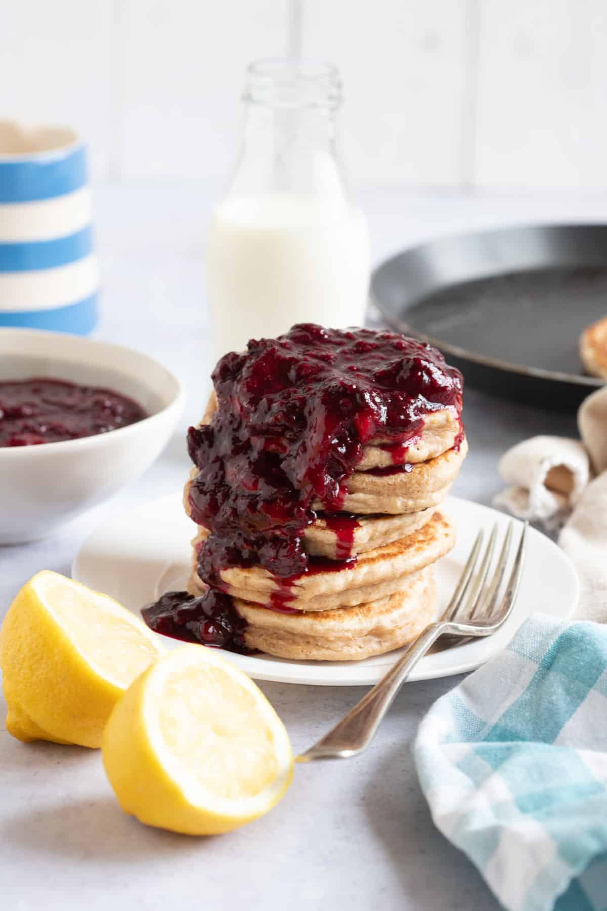 Frozen mixed berry compote spooned over a stack of pancakes.