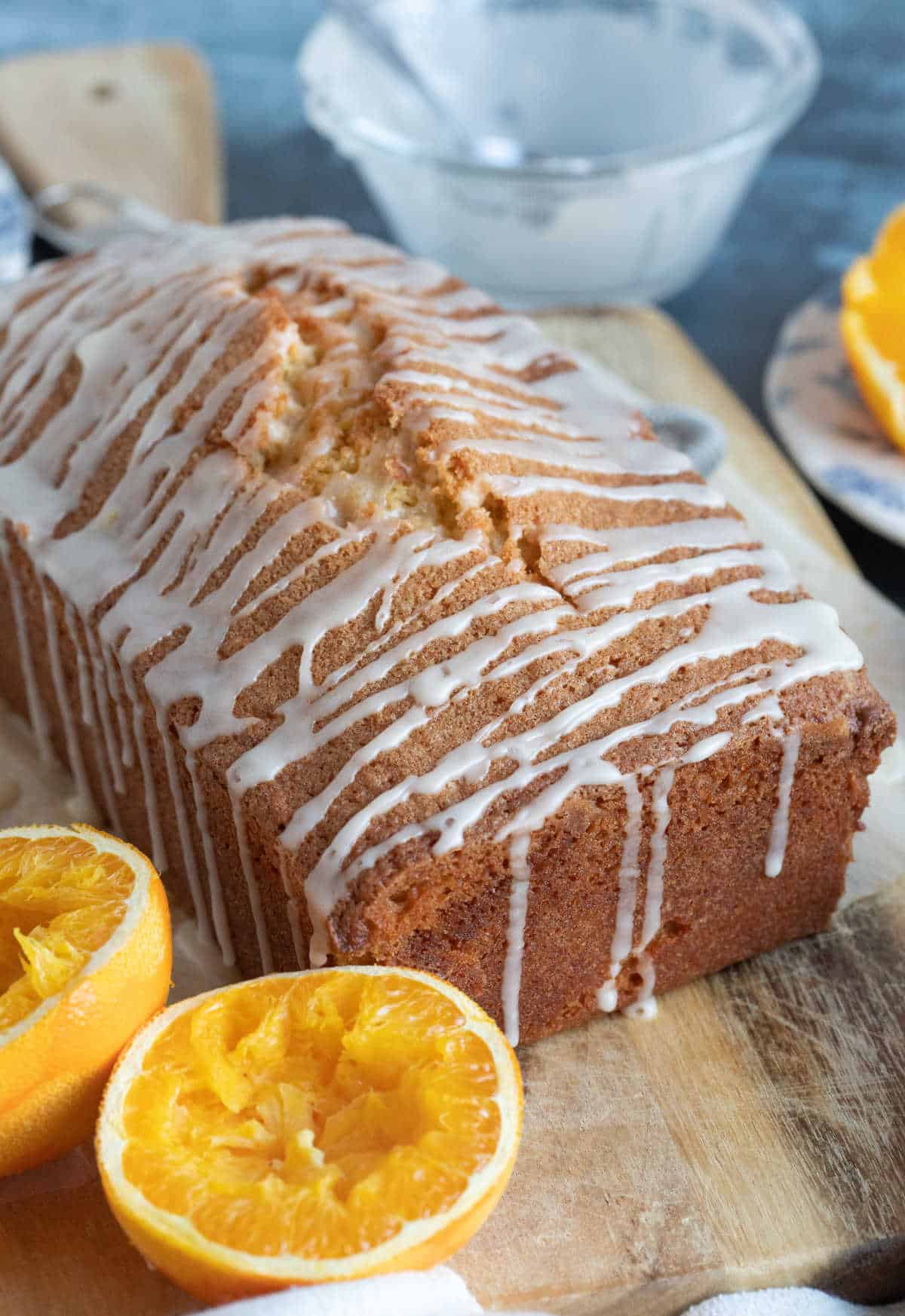 Orange drizzle icing running down the side of a loaf cake.