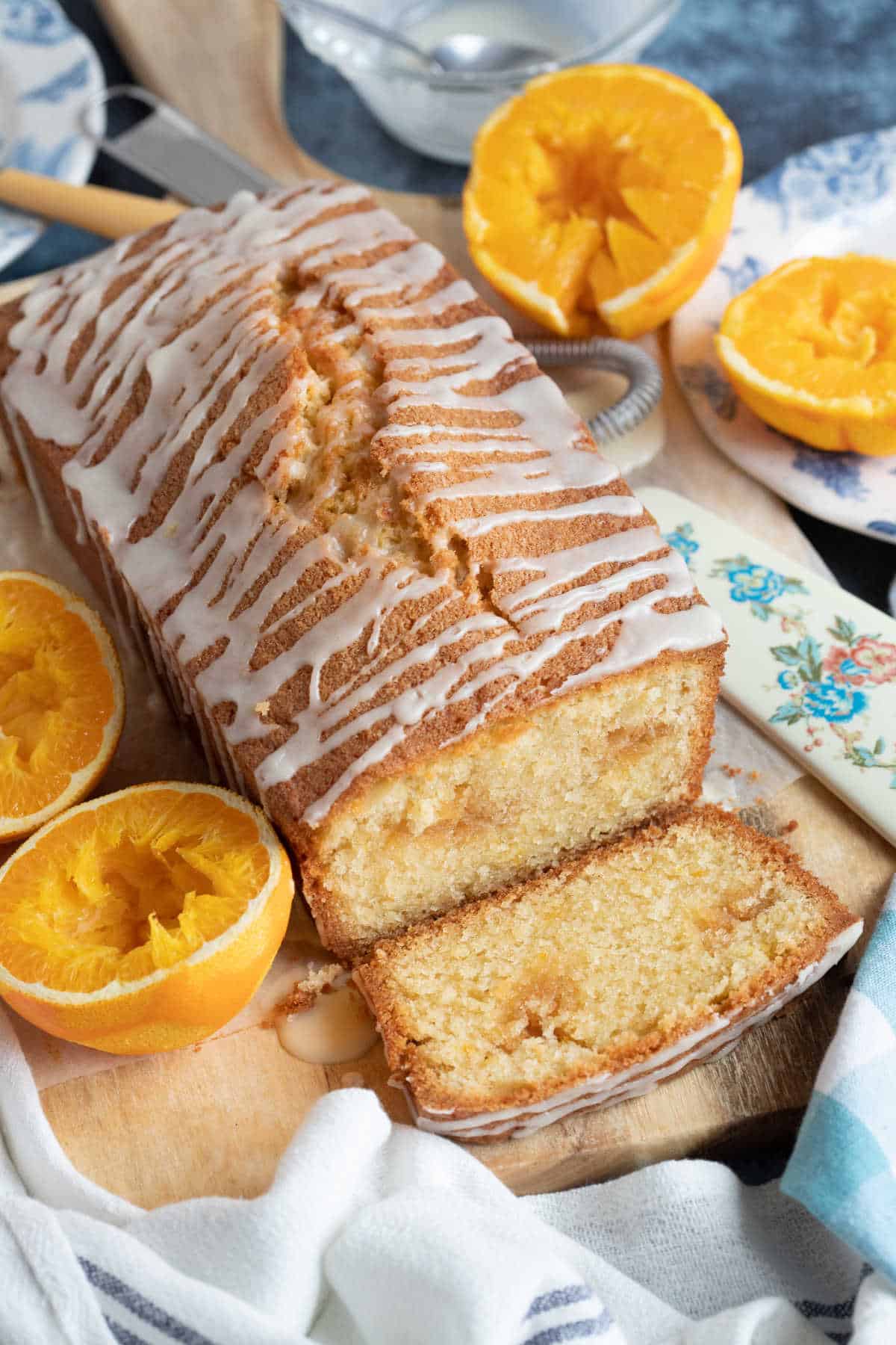 Marzipan loaf cake on a wooden board with a slice cut.