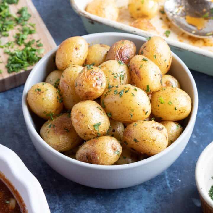 Roasted baby potatoes in a grey bowl.