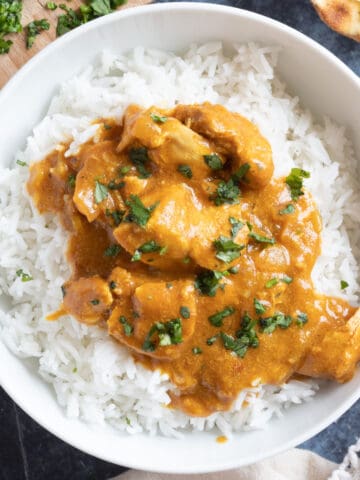 Slow cooker chicken curry garnished with chopped coriander.