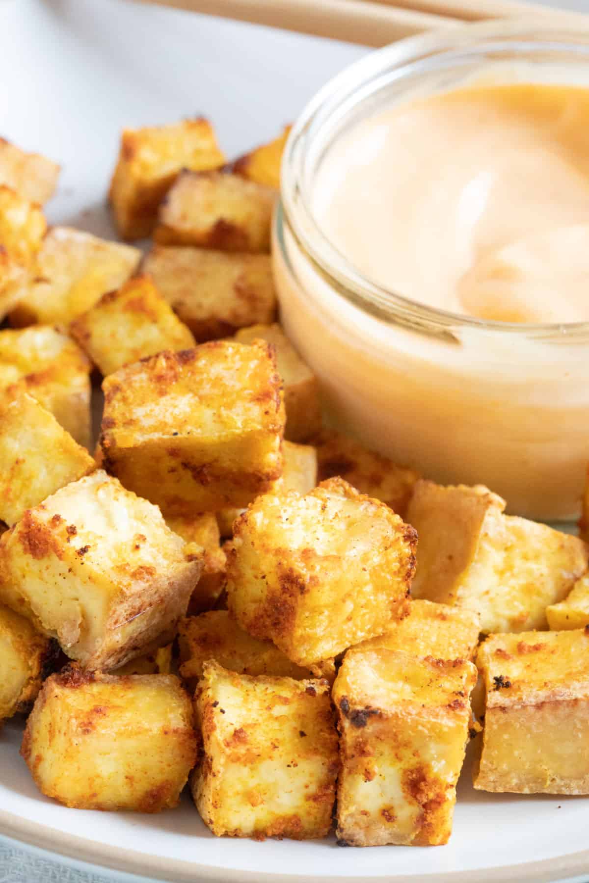 Crispy golden air fryer tofu cubes on a plate.
