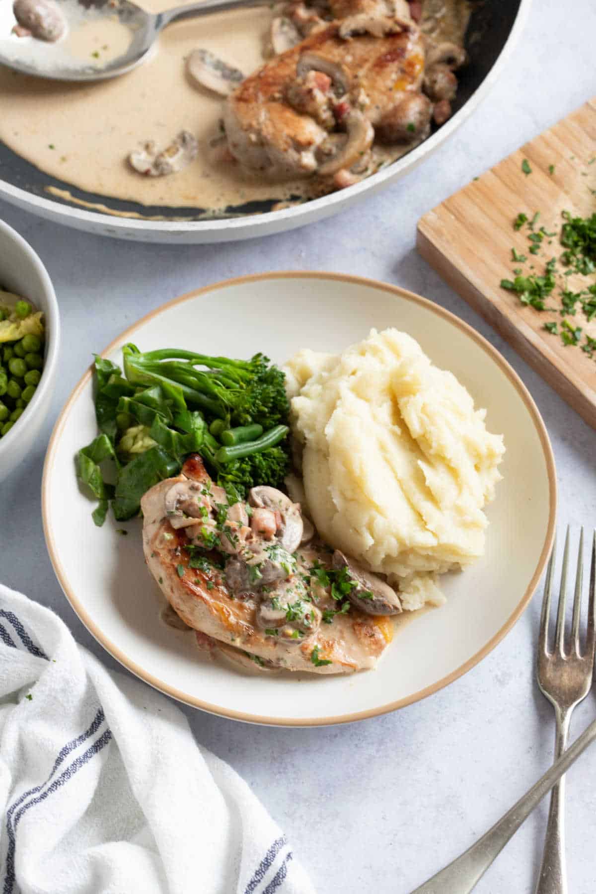 Pan fried pheasant breasts in a creamy sauce with mashed potato and green vegetables.