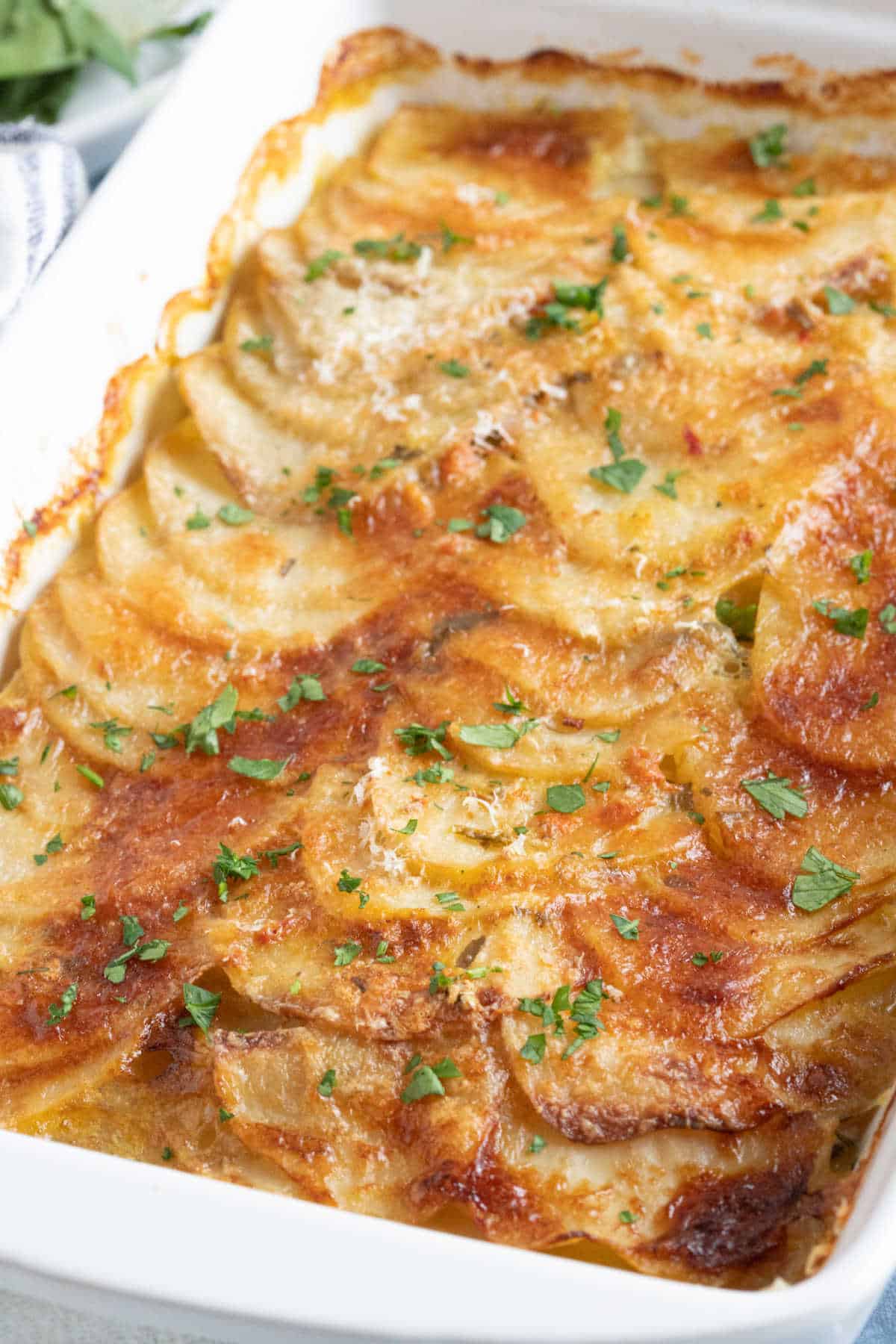 Boulangère potatoes in a white baking dish.