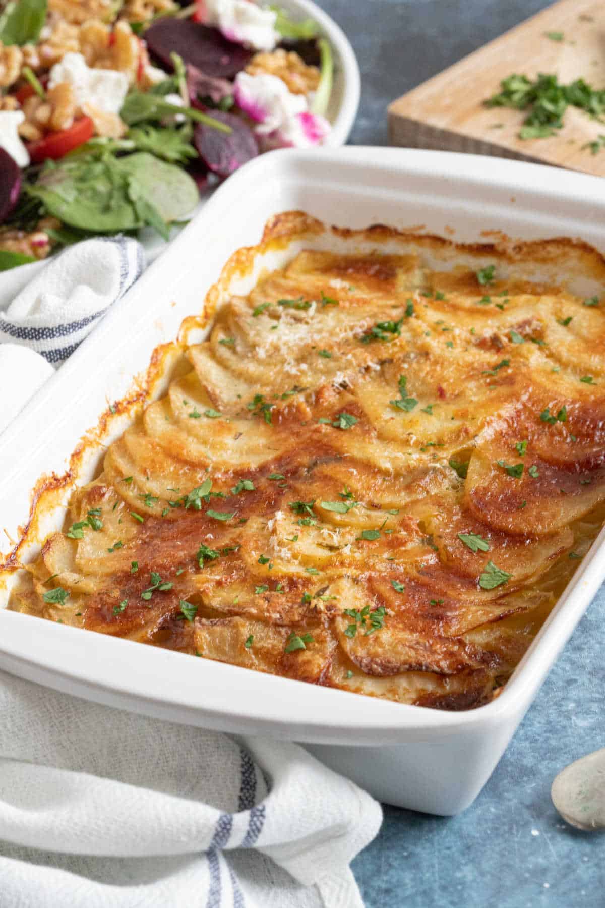 Boulangere potatoes in a white dish.