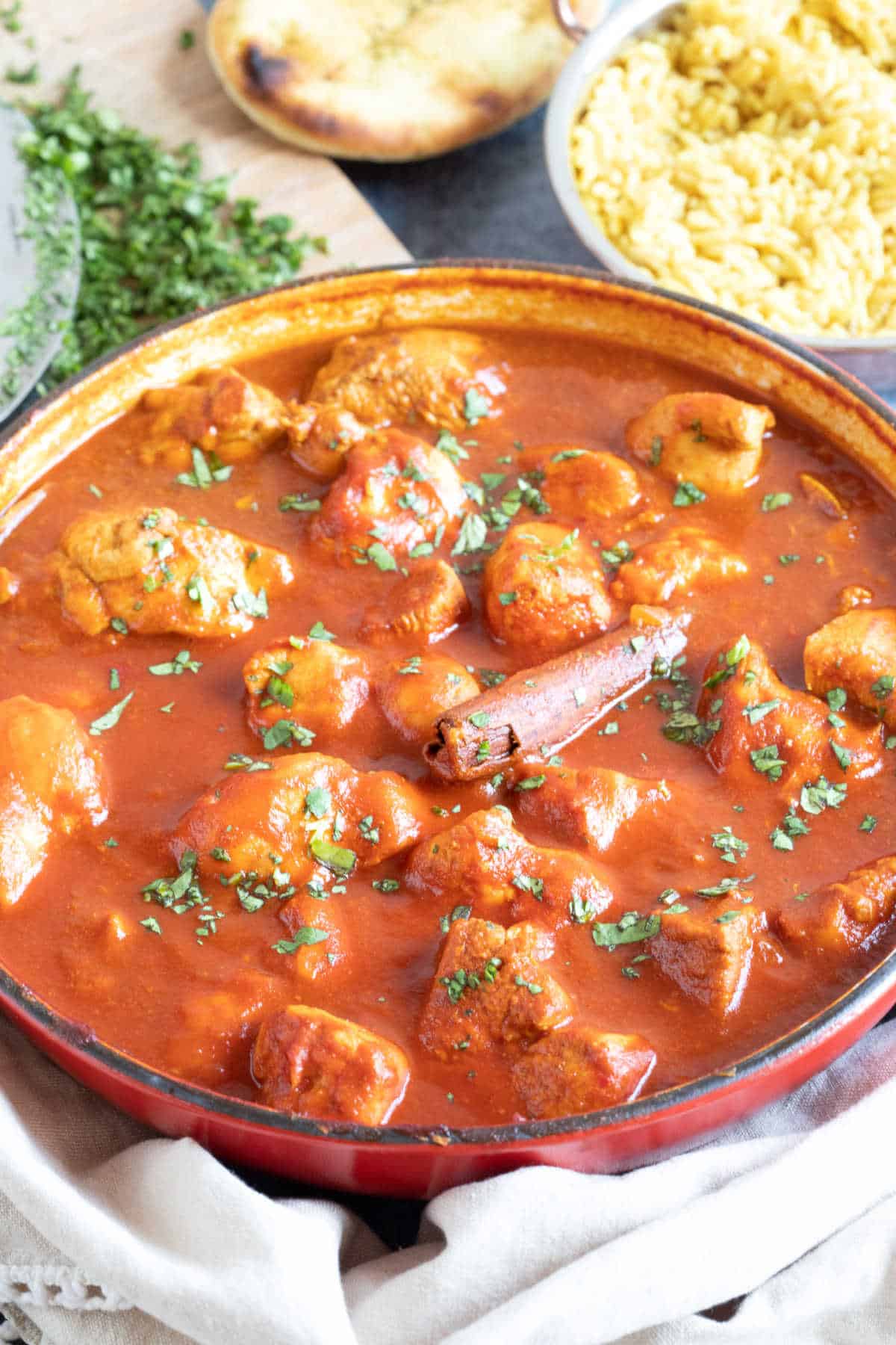 Chicken rogan josh in a red pan.