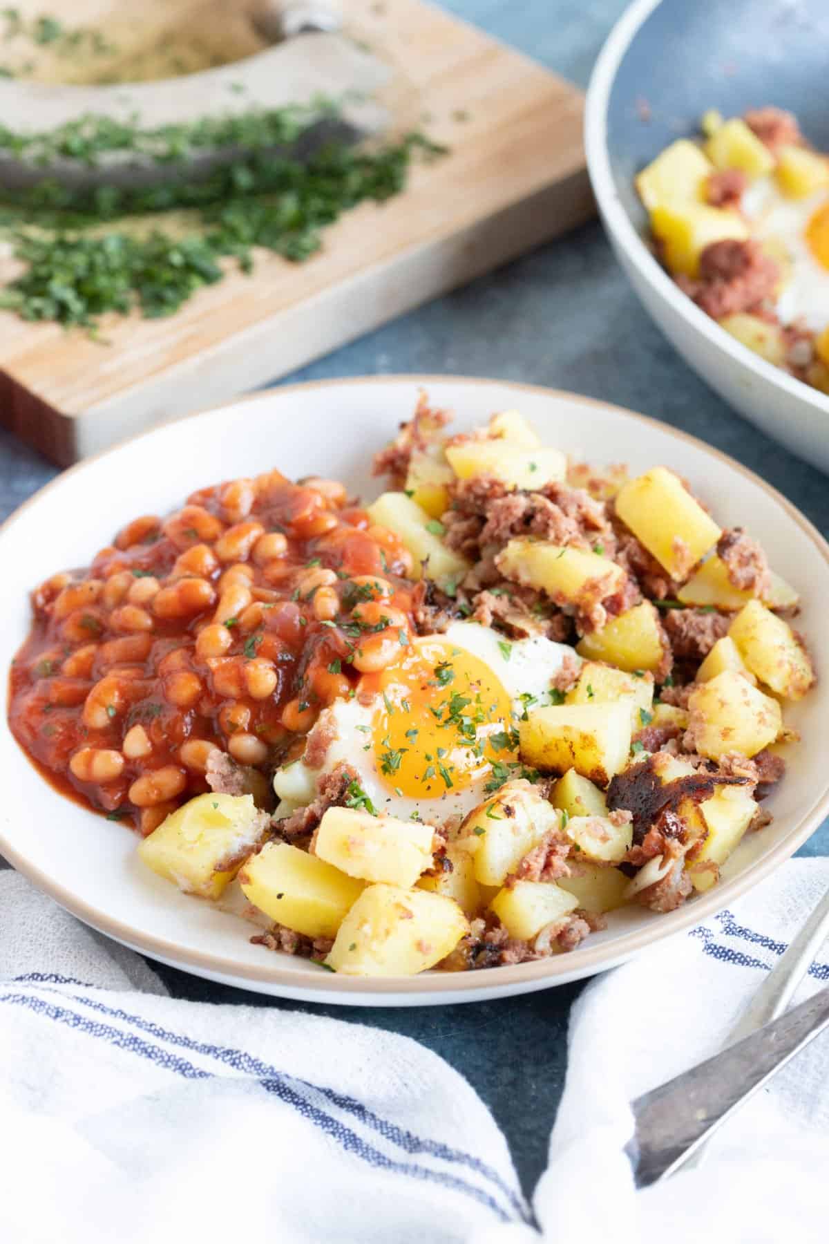 Corned beef hash with fried egg and  baked beans.