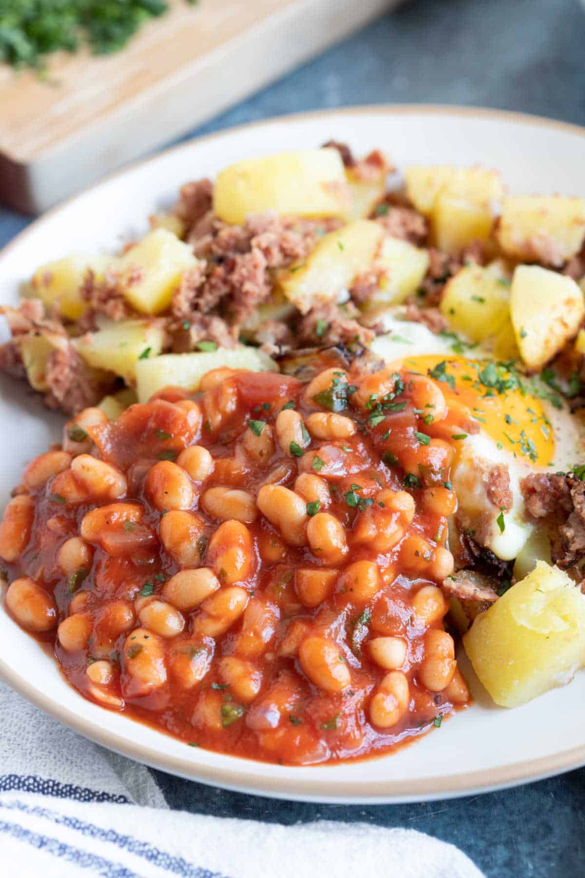 Homemade baked beans served with corned beef hash.