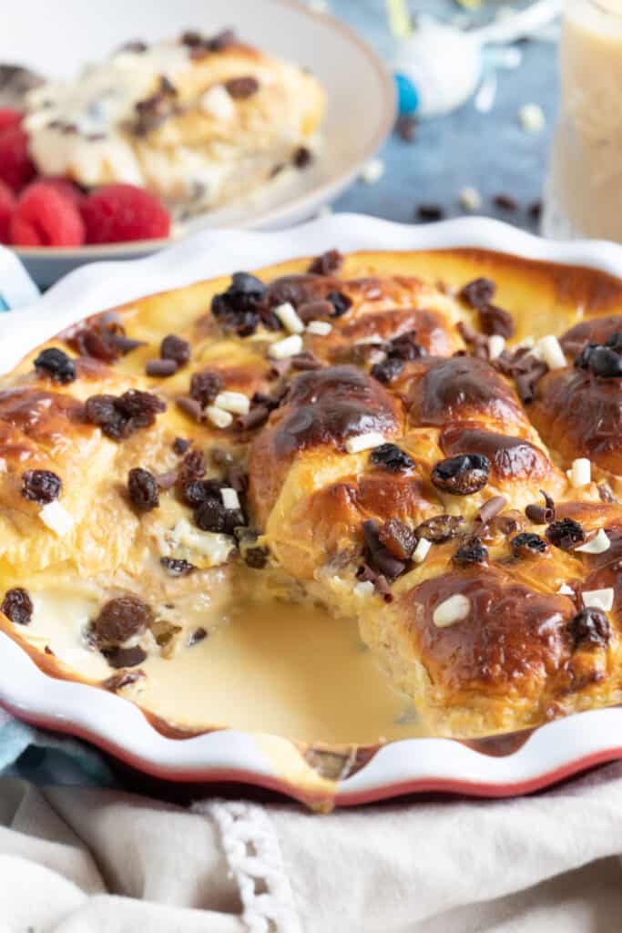 Hot cross bun pudding in a red pie dish.