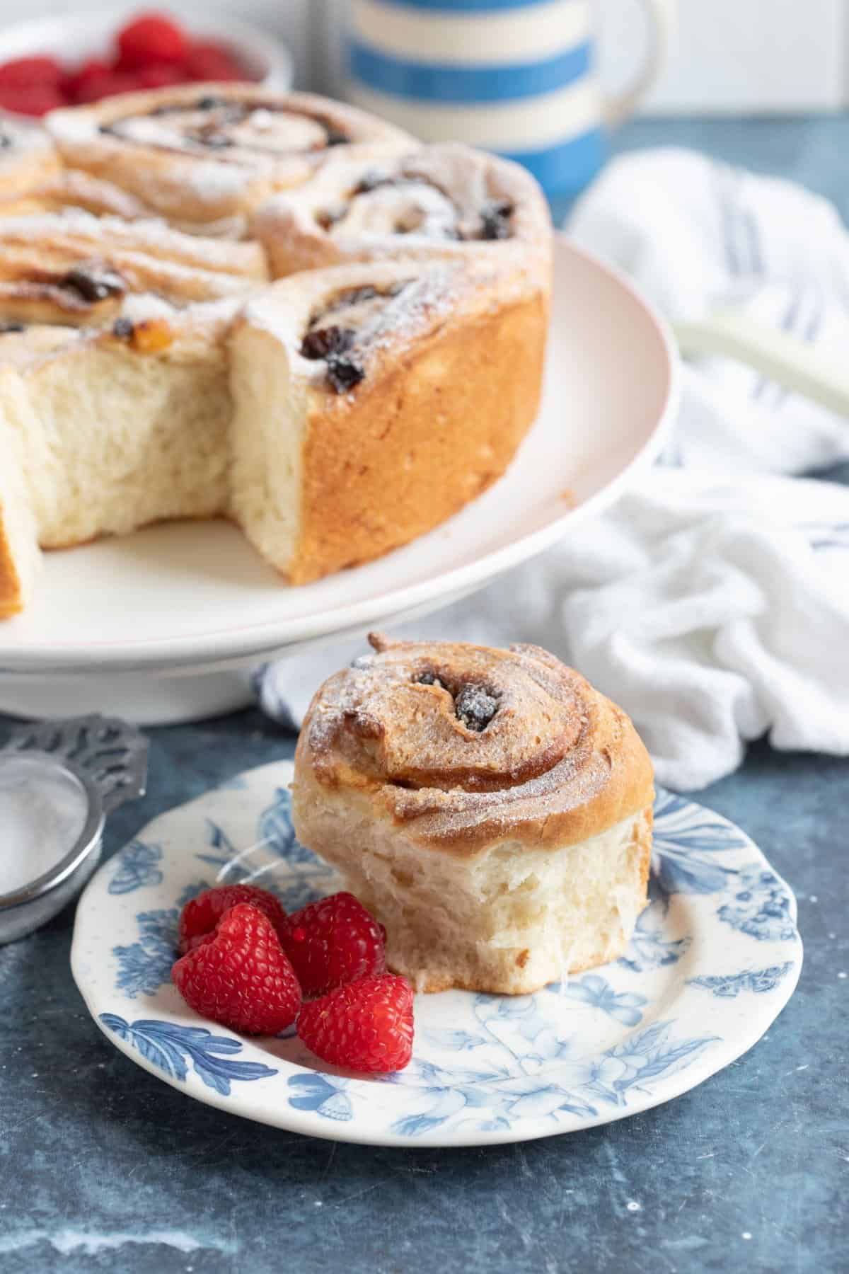 Lardy cake on a cake stand, with one piece on a cake plate.