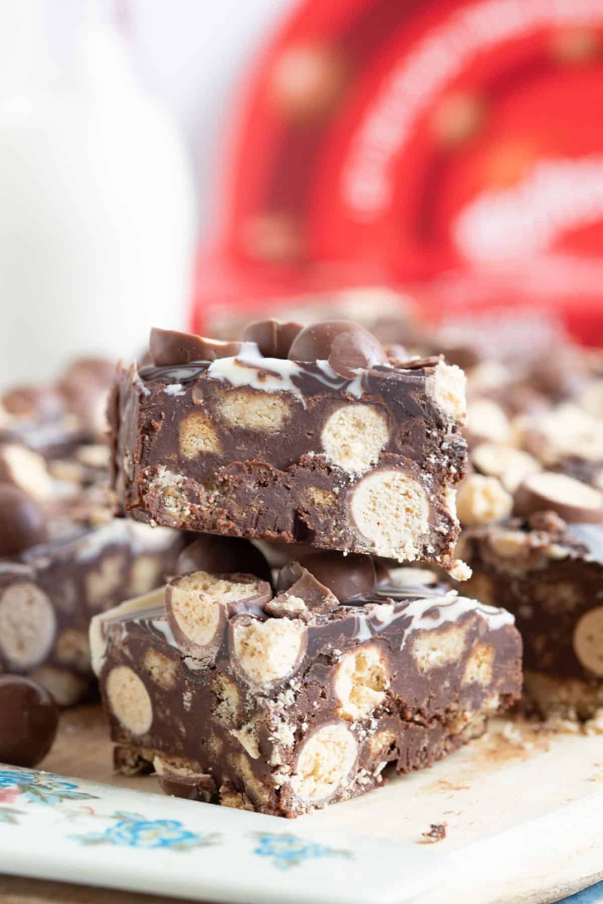 Chocolate malteser tiffin bars on a wooden board.