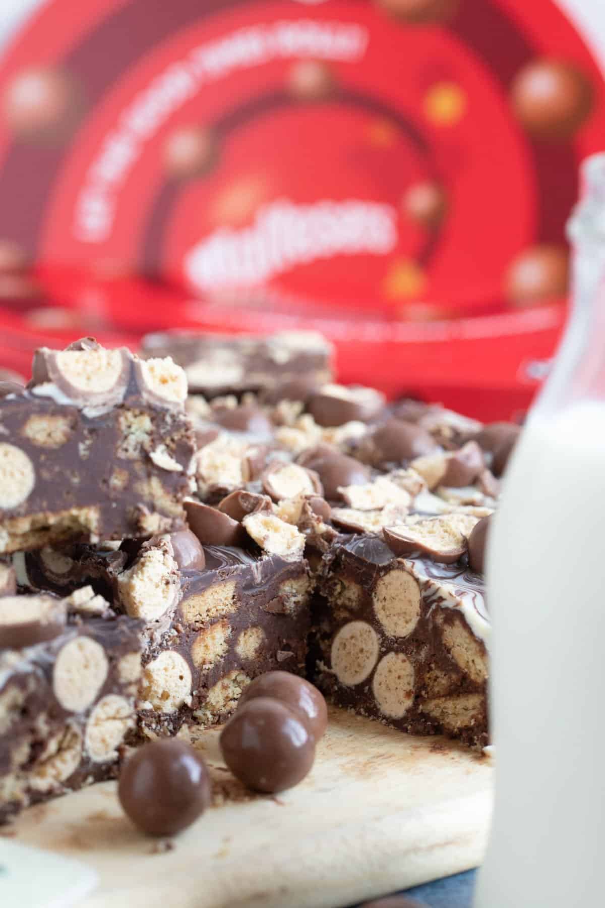 No bake Malteser traybake cut into bars on a wooden board.