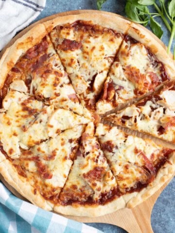 BBQ chicken pizza on a wooden board.