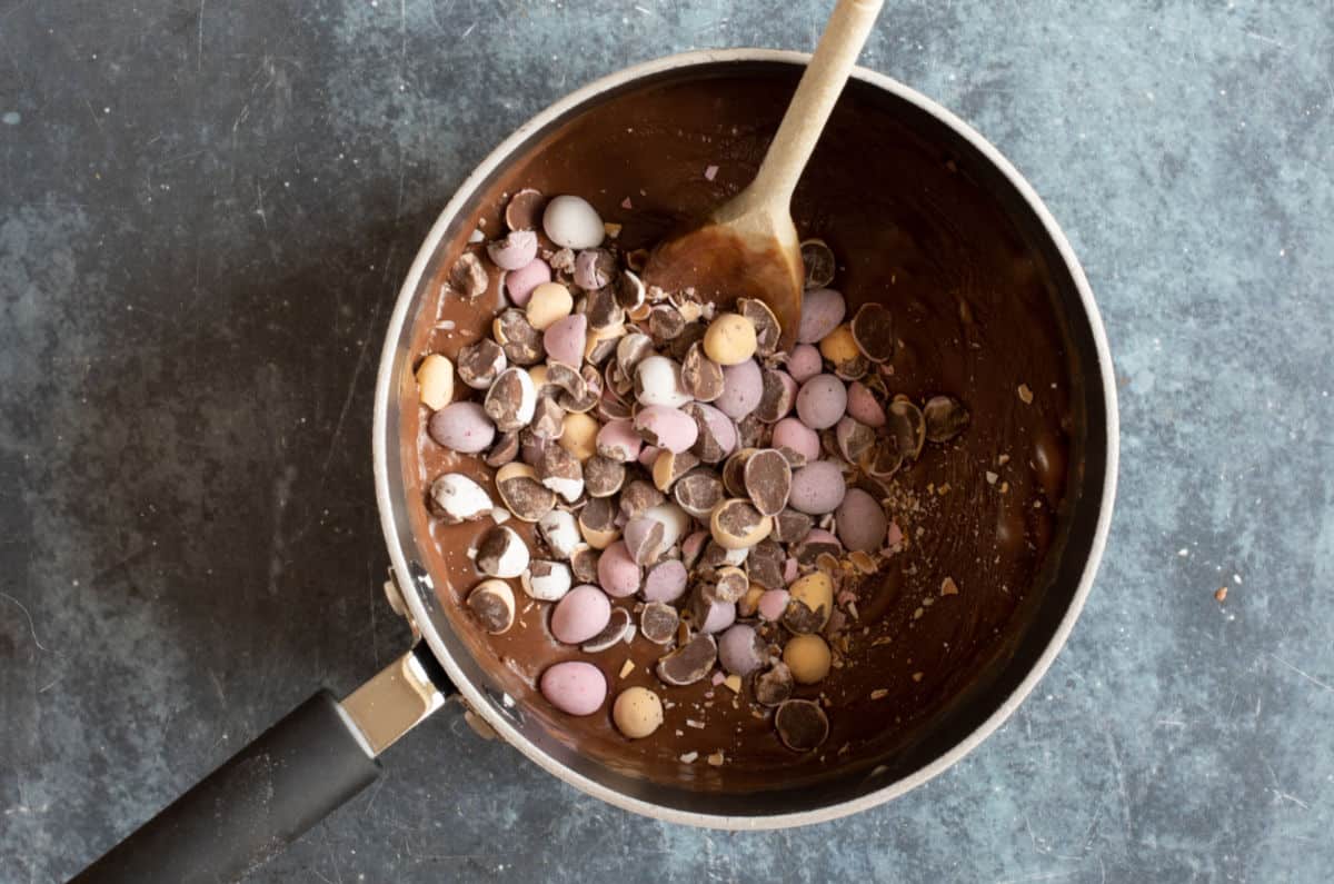 Adding mini eggs to the fudge.