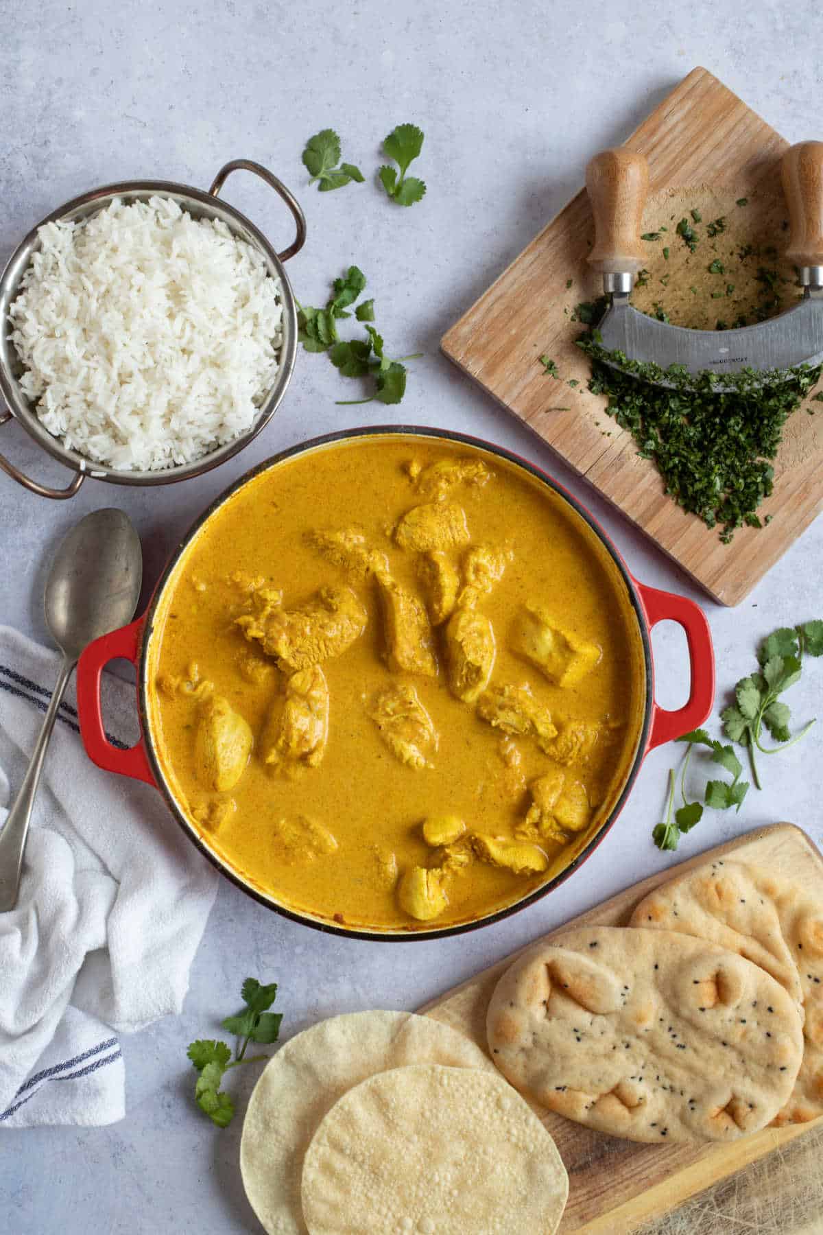 A pan of chicken korma with rice and coriander.