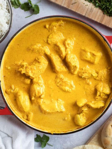 Chicken korma in a red pan.