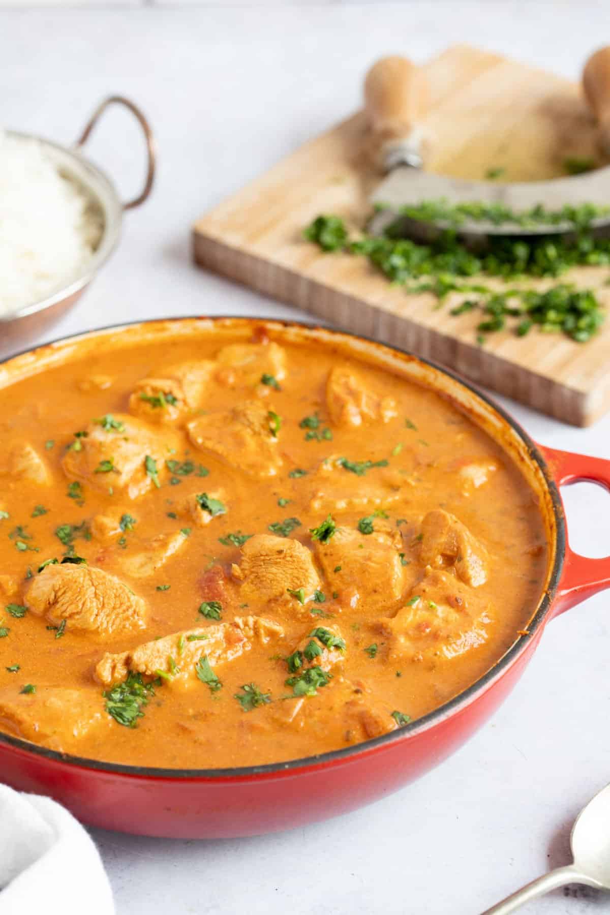 Chicken tikka masala in a red pan.