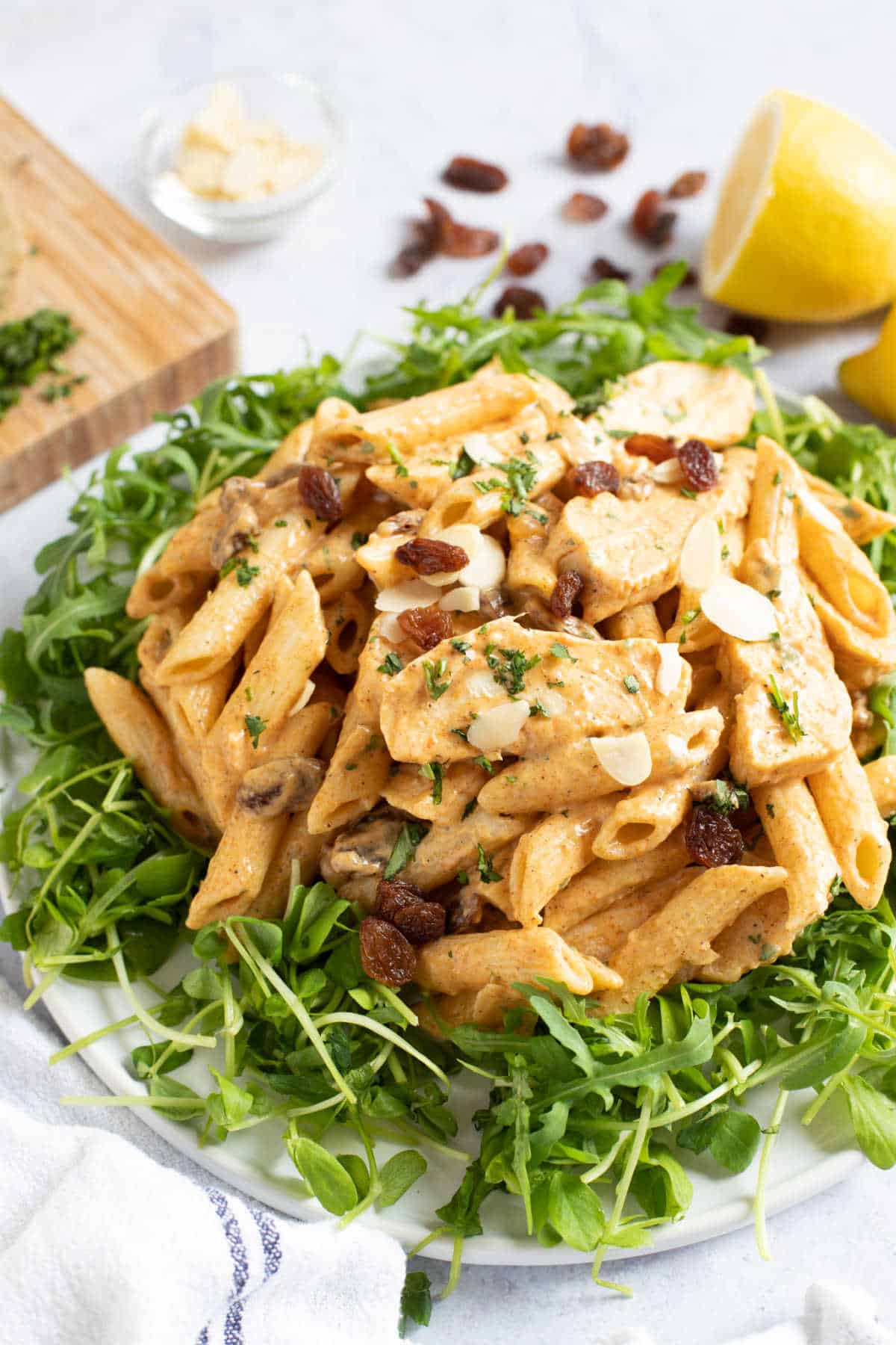 Curried chicken pasta salad on a bed of rocket leaves.