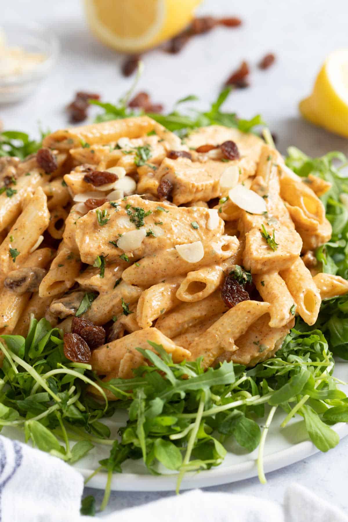 Coronation chicken pasta salad on a bed of rocket leaves.