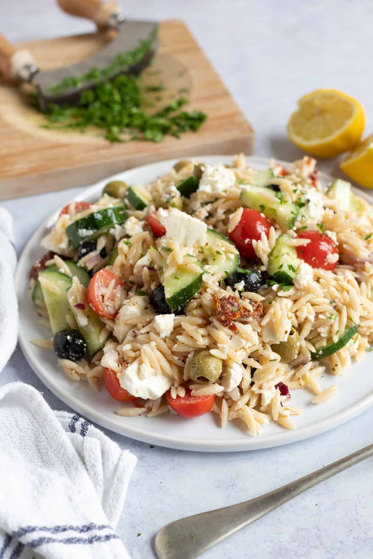 Greek orzo pasta salad on a white serving platter.