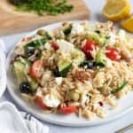 Greek pasta salad on a white plate.