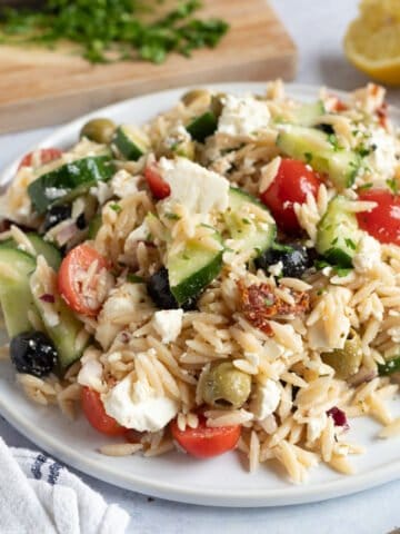 Greek pasta salad on a white plate.