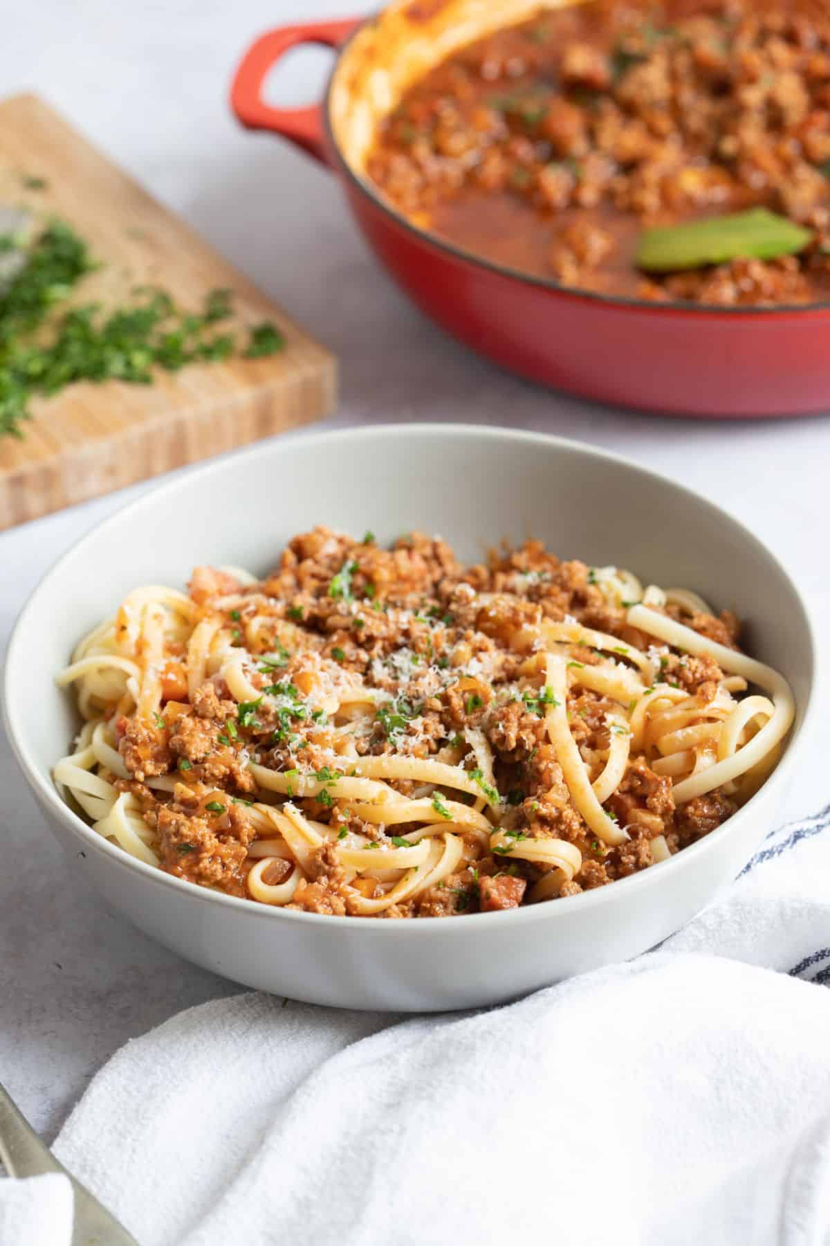 A bowl of lamb bolognese with grated parmesan.