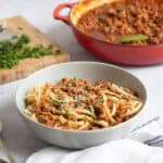 Lamb bolognese in a grey pasta bowl.