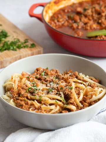 Lamb bolognese in a grey pasta bowl.