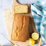 Madeira loaf cake on a wooden board with a slice cut.