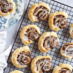 Puff pastry cinnamon swirls on a cooling rack.