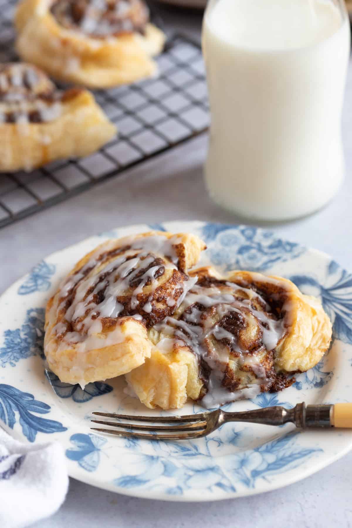 Puff pastry cinnamon swirls on a blue and white plate.