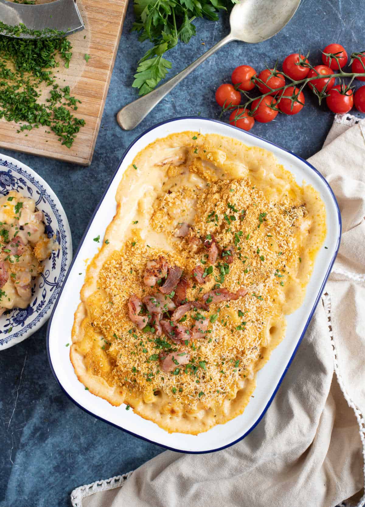 Macaroni cheese with bacon in a white enamel serving dish.