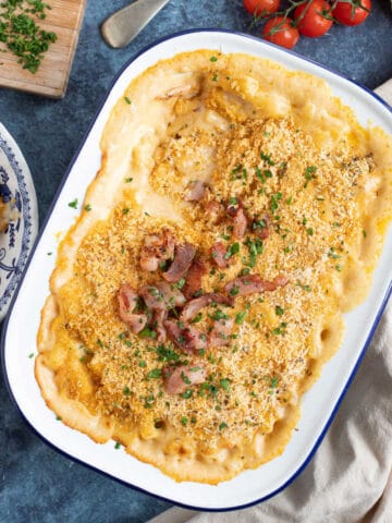 Bacon macaroni cheese with crispy bacon in a baking dish.