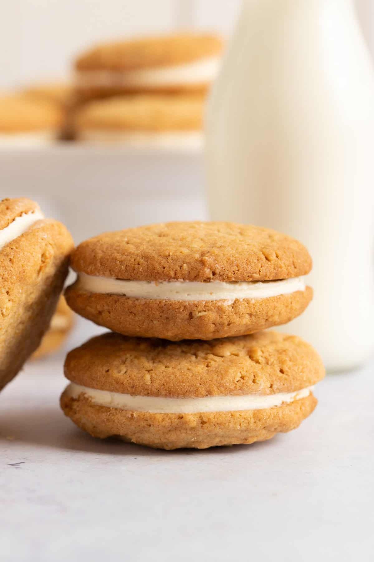 A stack of vanilla gypsy creams with a glass of milk.