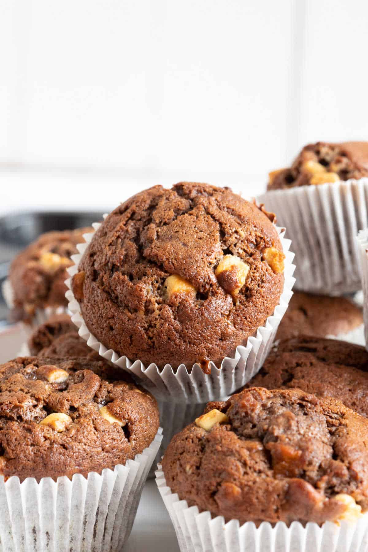 Chocolate banana muffins in white muffin cases.