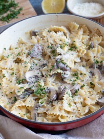 Garlic mushroom pasta in a red pan.