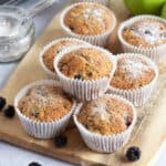 Apple and blackberry muffins on a wooden board.