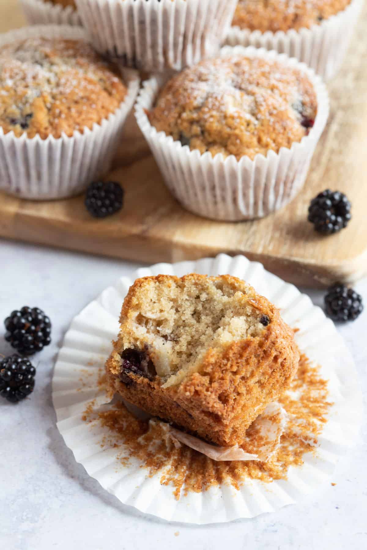 A half eaten muffin in its paper case.