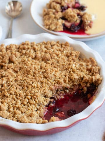 Blackberry and apple crumble in a red pie dish.