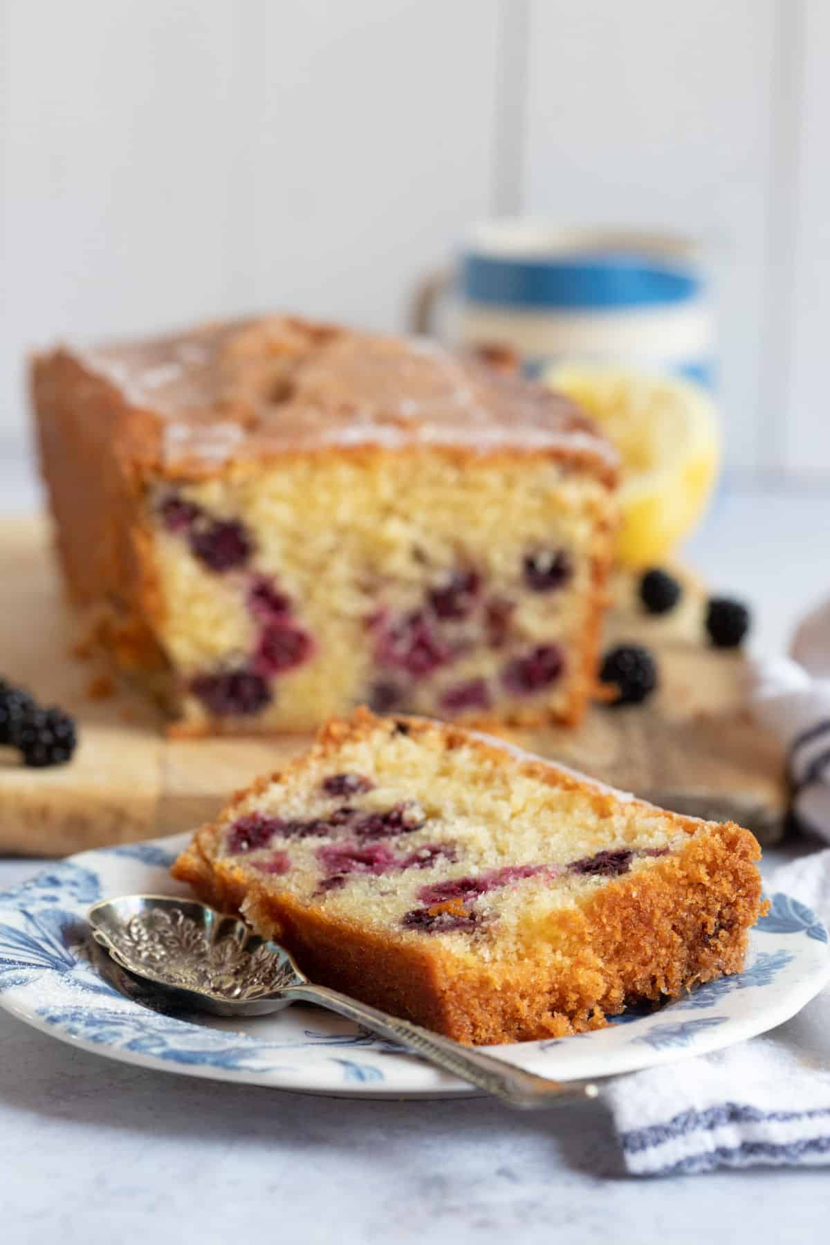 Blackberry and lemon loaf cake with a slice cut off the end.