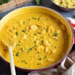 Prawn korma curry in a red pan.