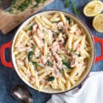 Salmon and prawn pasta with chopped dill on top.