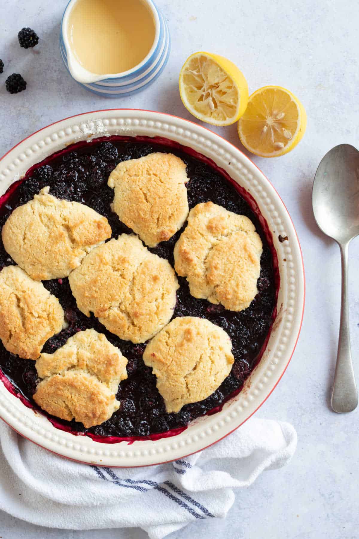 Blackberry cobbler in a red pie dish.